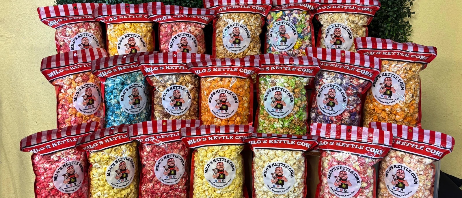 Milo's Kettle Corn market display: rows of red and white bags stacked three deep.